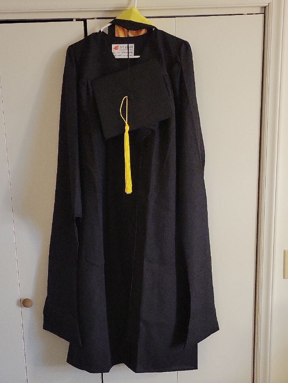 Black Masters Degree Graduation Gown with Cap, Yellow Tassel, and Yellow Sash.